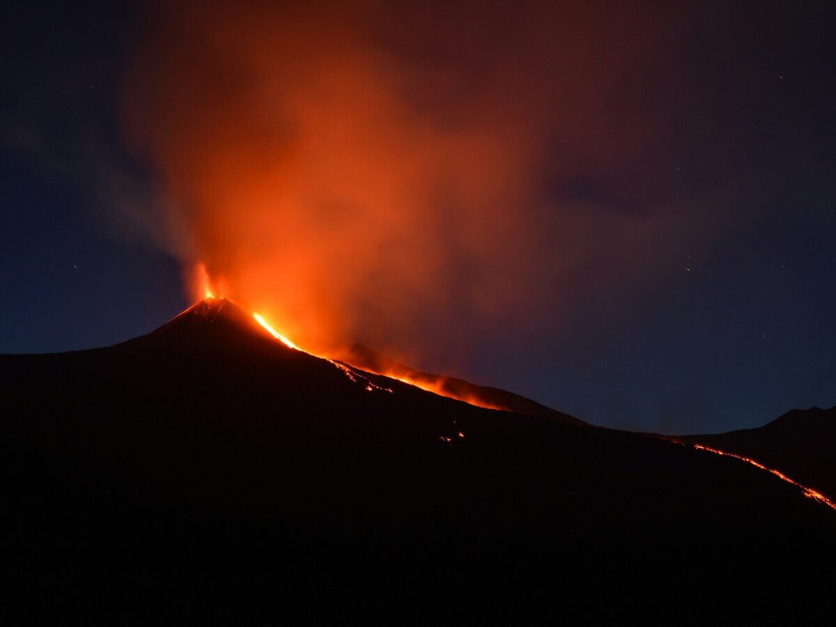 Mount Etna in eruptie met lavastromen tegen nachtelijke hemel